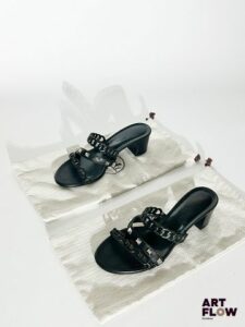 HERMES Modèle "Ajaccio" Paire de sandales à talons en cuir lisse nappa noir, brides cloutées, les autres rappelant le motif celebre "chaine d'ancre" de la maison Hermès. Pointure 36 Talon : 4,5 cm Très bon état général, avec son pochon et sa boite d'origine