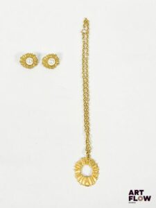 JACQUES ESTEREL Demi-parure composée d'une paire de clips, chacun orné d'une perle fantaisie encerclée de métal doré recouvert de cordage, et d'un collier dont le pendant est un anneau présentant le même motif Dimensions du pendentif 3,5 cm Dimensions chaîne fermée et pendentif 26cm Dimensions des clips 2,5 cm Bon état général malgré les protections noircis des clips