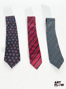 Lot de 3 cravates, comprenant : - CHANEL, cravate à losange sur fond bleu marine - COURREGES, cravate à rayure rouge et bleu marine - CHRISTIAN DIOR, cravate à motif dans les tons bleus Bon état général