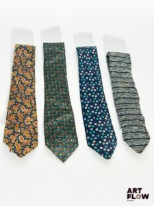 Lot de 4 cravates, comprenant : - PIERRE BALMAIN, cravate en soie à fleurs dans les tons verts et marrons - BURBERRY, cravate à motif de demi-pomme dans les tons bleus - NINA RICCI, cravate en soie motif paisley dans les tons ocres et bleus - MIYAKE DESIGN STUDIO, cravate en soie à rayure bleue Bon état général