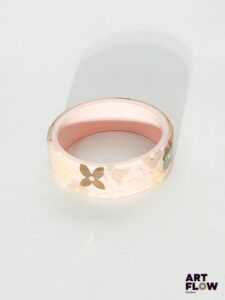 LOUIS VUITTON Bracelet jonc en résine transparente sur fond rose à motif en inclusion monogramme Diamètre intérieur 6,5 cm