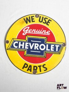 Plaque émaillée ronde Chevrolet "We use genuine Chevrolet parts" diamètre 30 cm Petits éclats et traces de rouille Reproduction moderne