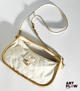 PRADA Sac bandoulière en nylon blanc et cuir saffiano blanc et doré, bijouterie en métal doré, fermeture éclair. Dimensions : H. 13,5 x L. 25,5 cm Tâches de jaunissement