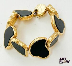 YVES SAINT LAURENT Bracelet articulé en métal doré composé de coeurs stylisés en bois Signé Longueur : 20 cm environ