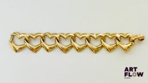 YVES SAINT LAURENT Bracelet en métal doré avec maillons en forme de cœurs Signé Longueur : 18 cm environ Très légères usures d'usage