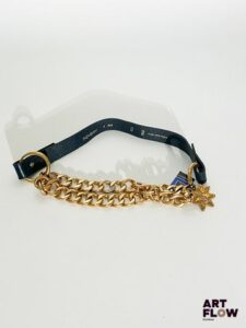 YVES SAINT LAURENT Ceinture en cuir bleu marine et chaîne, avec une bijouterie dorée et un charm en forme d'étoile portant l'inscription « YSL ». Dimensions : environ 81 × 2,5 cm. Traces d'usure et décoloration de la bijouterie