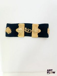 YVES SAINT LAURENT Ceinture en élastique noir ornée de bijoux dorés en forme de soleil typique d'Yves Saint Laurent. Dimensions : 60 x 10 cm Bon état général