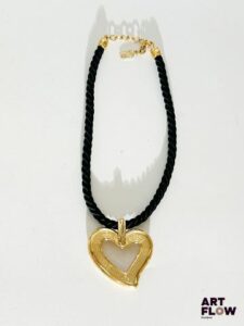 YVES SAINT LAURENT Collier en corde orné d'un pendentif formant coeur en métal doré Signé Dimensions du pendentif 5 x 6 cm Élément décollé à l'arrière