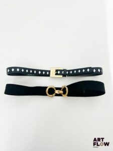 YVES SAINT LAURENT Lot de 2 ceintures comprenant - Une ceinture bleu marine avec des losanges blancs, avec une bijouterie dorée. Dimensions (sans la boucle) : 81 × 2 cm. Très bon état général. - Une ceinture élastique noire ajustable, avec une bijouterie dorée de style bambou. Dimensions (sans la boucle) : 85 × 3 cm. Usures au niveau de la bijouterie.
