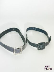 YVES SAINT LAURENT Lot de 2 ceintures comprenant : - Une ceinture en daim bleu marine avec une bijouterie argentée. Dimensions (sans la boucle) : 86 × 3,5 cm. Marques d'usure. - Une ceinture en cuir bleu marine avec des rayures. Dimensions (sans la boucle) : 85 × 3 cm. Marques d'usure.