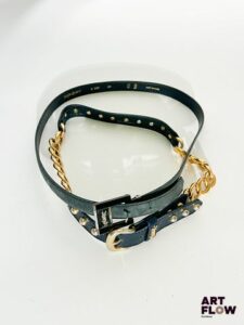 YVES SAINT LAURENT Lot de 2 ceintures : Une ceinture en cuir noir avec des perles et une chaîne dorée. Dimensions (sans la boucle) : 85 × 2,5 cm. Bijouterie usée. Une ceinture en daim noir avec une bijouterie argentée. Dimensions (sans la boucle) : 98 × 2 cm.