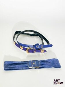 YVES SAINT LAURENT Lot de 3 ceintures comprenant : - Une ceinture en cuir violet avec une boucle en forme de cœur et une bijouterie dorée. Dimensions (sans la boucle) : 83 × 2 cm. Bon état général. - Une ceinture en daim violet avec une bijouterie dorée présentant des cœurs sur la boucle et le long de la ceinture, ainsi qu'un charm en forme de cœur portant l'inscription « Yves Saint Laurent ». Dimensions (sans la boucle) : 82 × 2,5 cm. Bon état général. - Une ceinture bleu roi avec une bijouterie dorée. Dimensions (sans la boucle) : environ 64 × 6 cm. Usures.