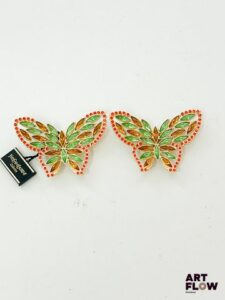 YVES SAINT LAURENT Paire de clips d'oreilles en forme de papillons en métal doré à décor de stars multicolores Signés Dimensions : 7 x 4,5 cm
