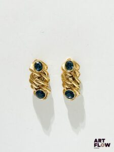 YVES SAINT LAURENT Paire de clips d'oreilles en métal doré orné chacun de deux strass bleu Signés Hauteur : 4,5 cm